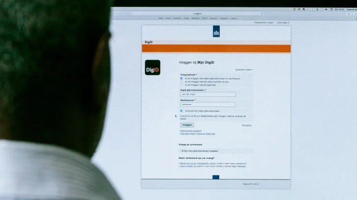 Man voor computerscherm met DigiD pagina erop